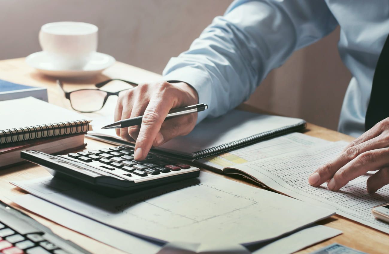 Eine Person rechnet etwas mit einem Taschenrechner aus